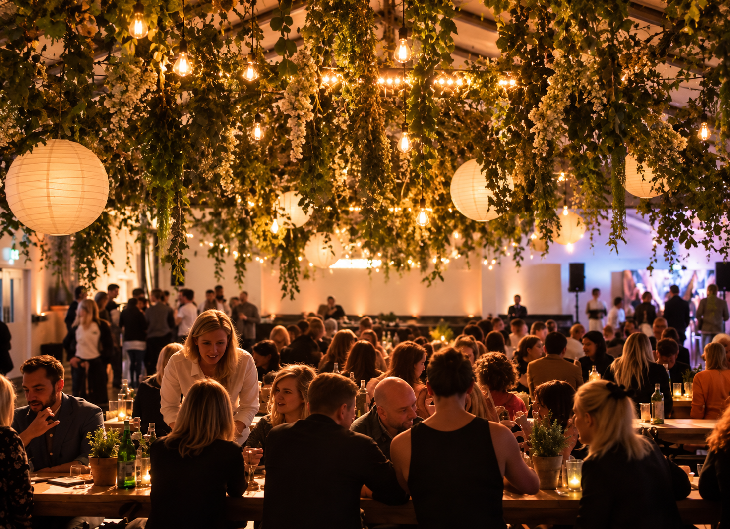 Guests dining beneath a botanical ceiling installation