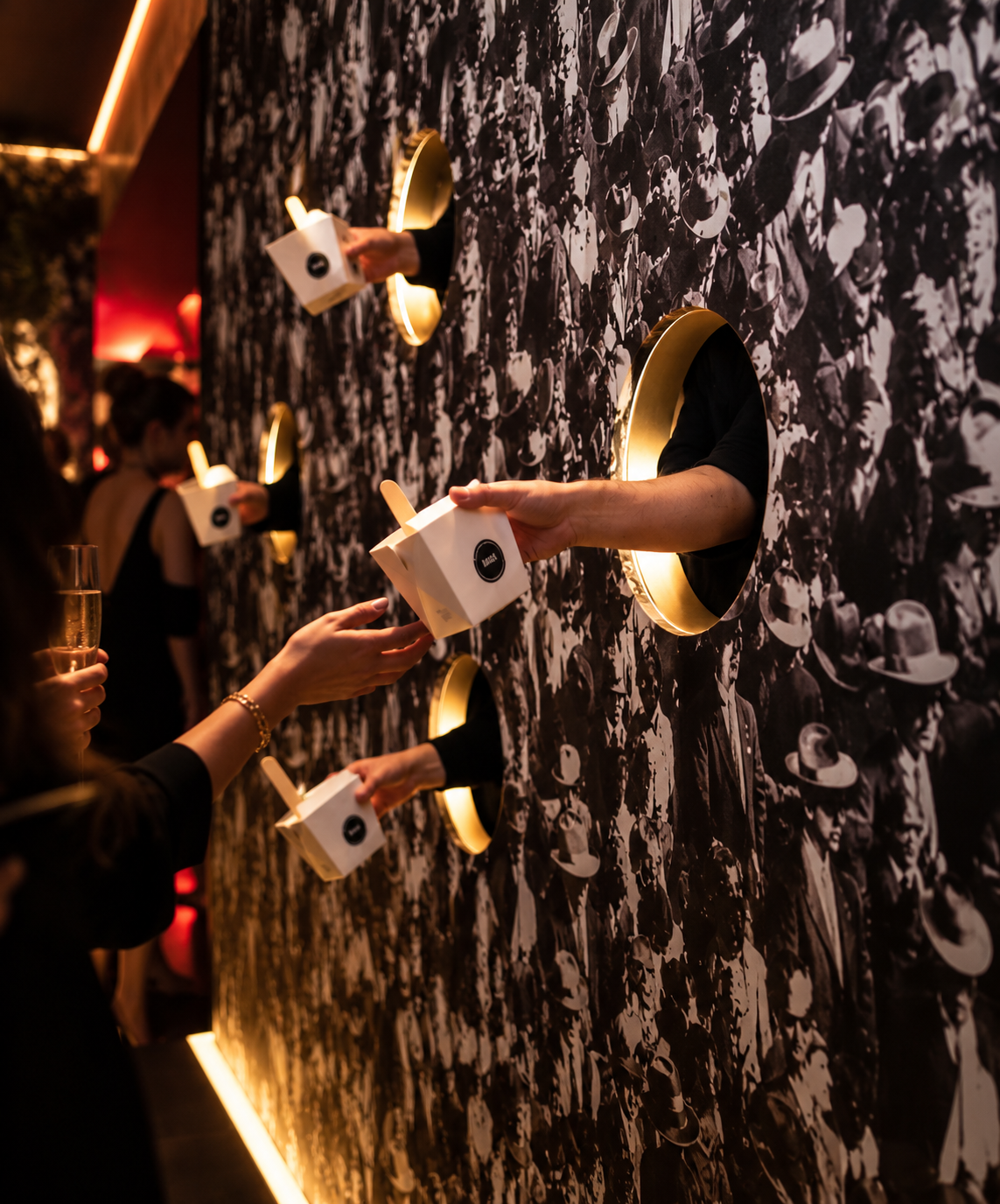 Guests receiving dishes through an interactive serving wall